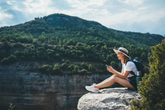 Young woman in nature playing lotto on phone