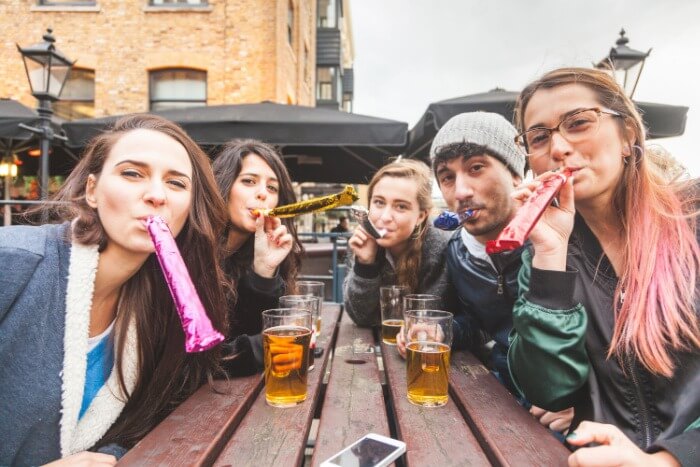 Friends at the pub with party blowers