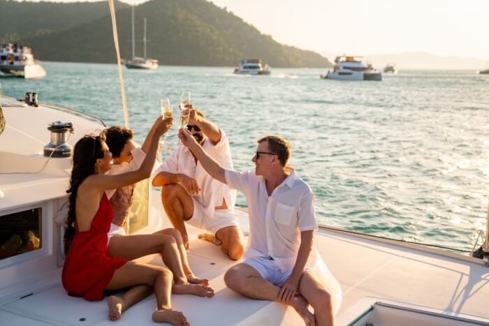 Friends drinking champagne on yacht at sunset