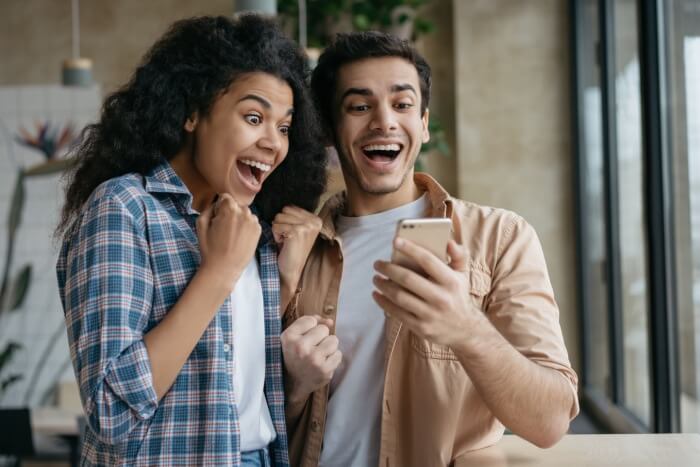 Young couple looking at phone in excitement